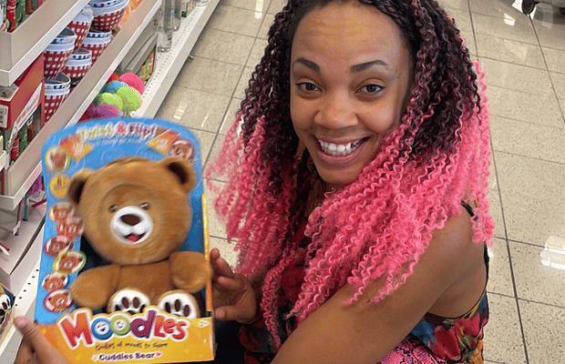 Azhelle Wade holding a client's toy on a store shelf